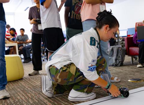Student places robot car on race track.